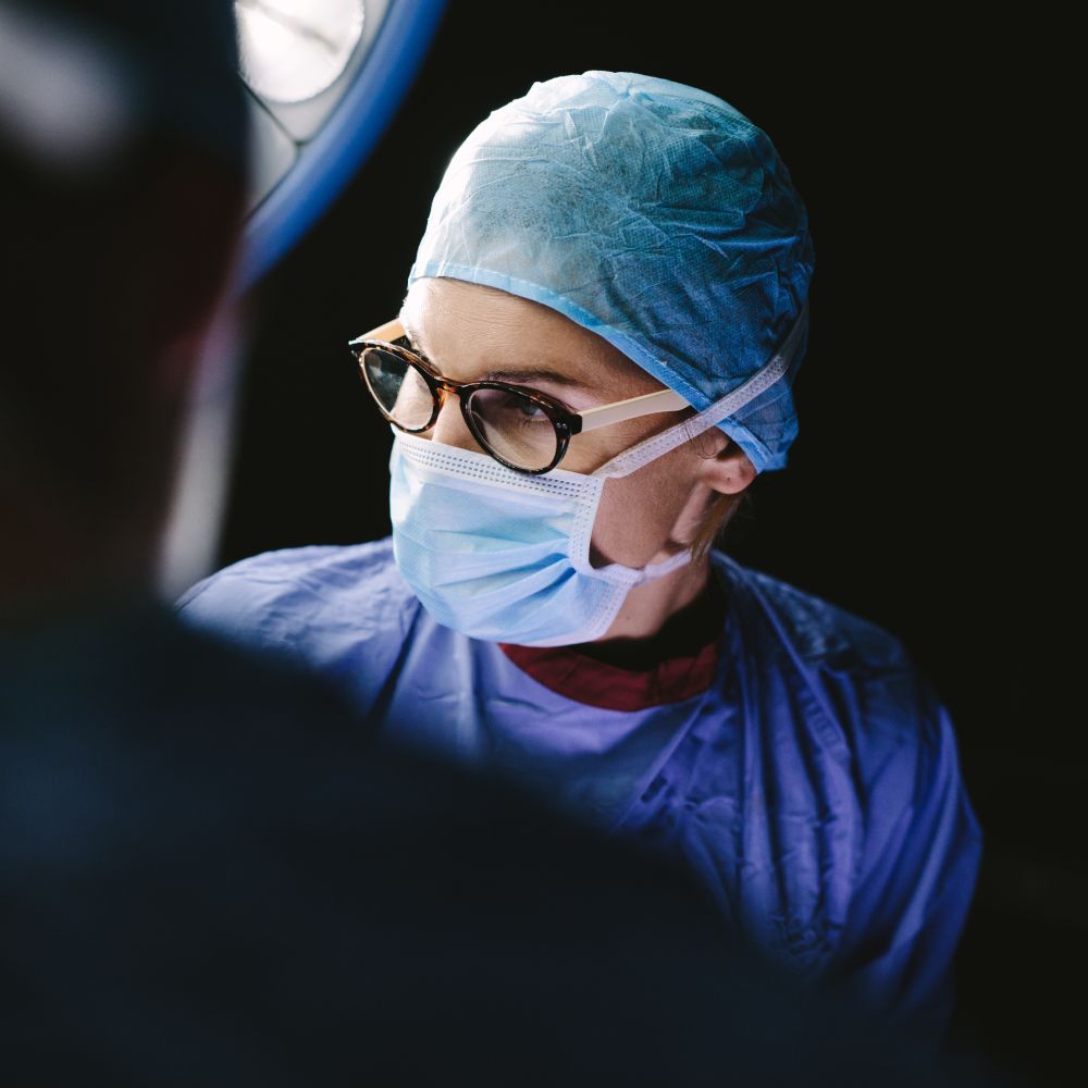 A surgeon attentively examining a patient in a hospital, ensuring precise care and attention.